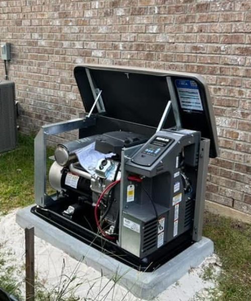 A generator is sitting outside of a brick building