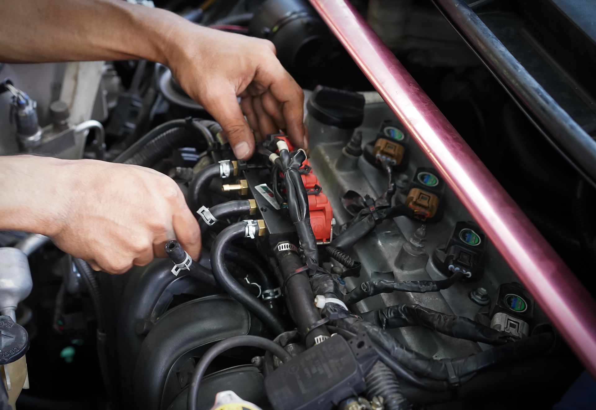 A man is working on the engine of a car.