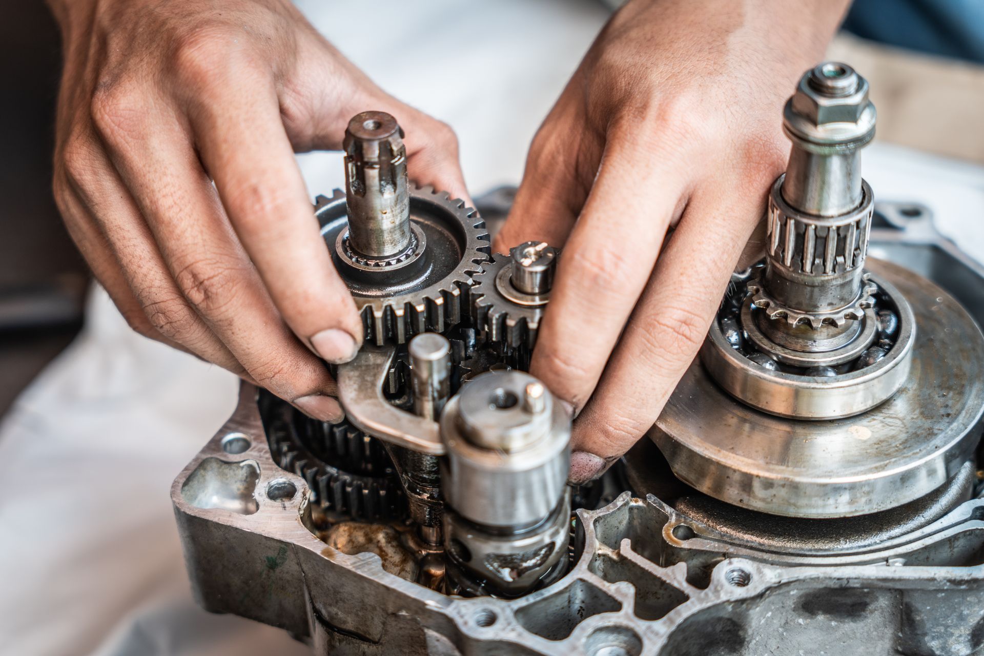 A person is working on a gearbox on a motorcycle.