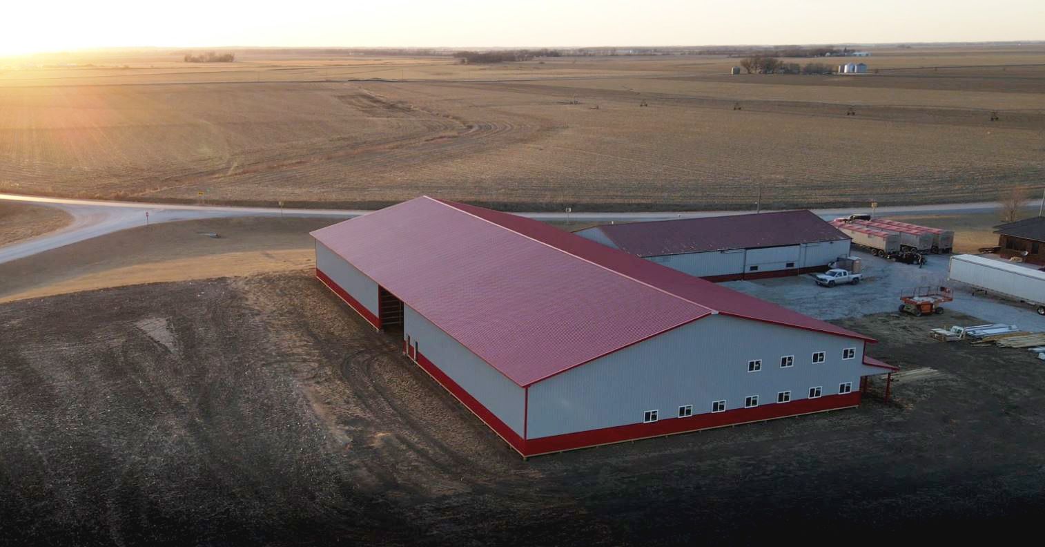 Red barn with white trim against a bright blue sky.