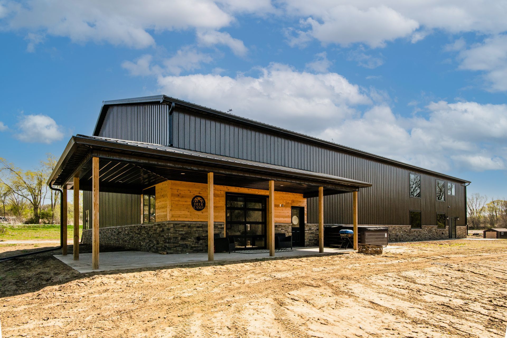 Black metal barn with a covered porch.
