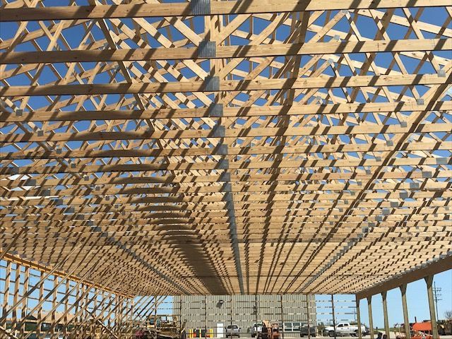 Wooden framework of a building under construction against a blue sky.