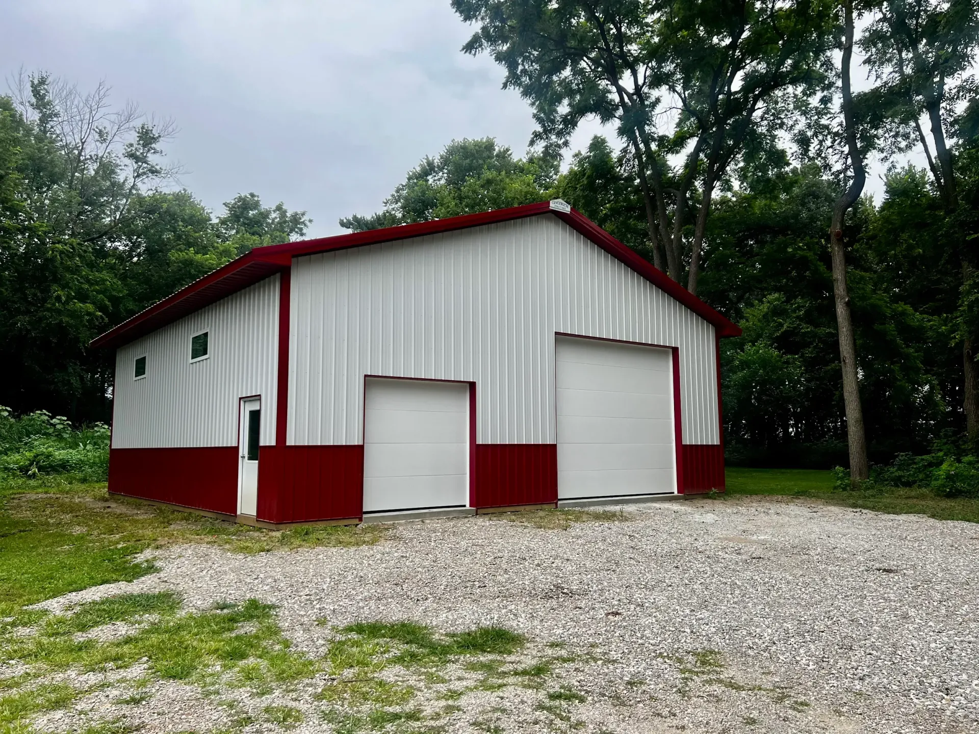 A large metal building with a brown roof, tan walls, and a brown lower wall section on a sunny day.