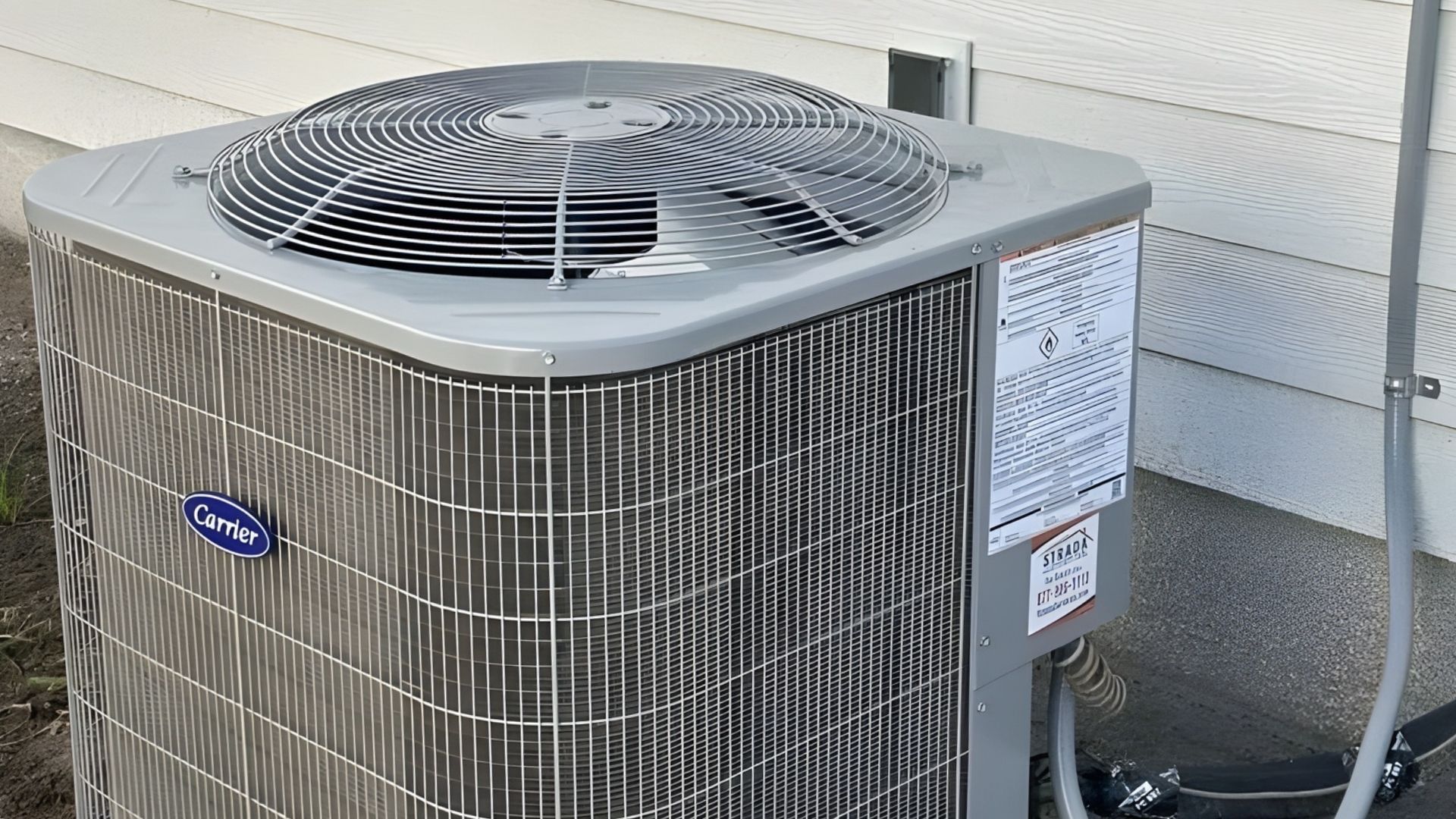 An air conditioning unit outside a building with a fan on top.
