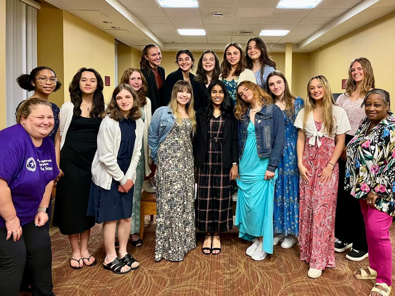 A group of young women are posing for a picture in a dormitory lobby