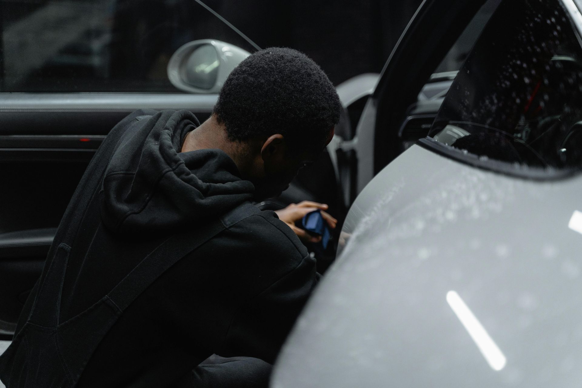 A man is sitting in a car looking at his phone.