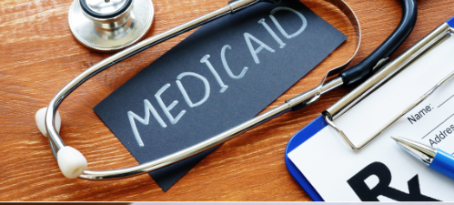 A stethoscope and a clipboard with the word medicaid on it