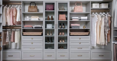 A walk-in closet with pastel-colored clothes, handbags, and shoes displayed on gray shelving.