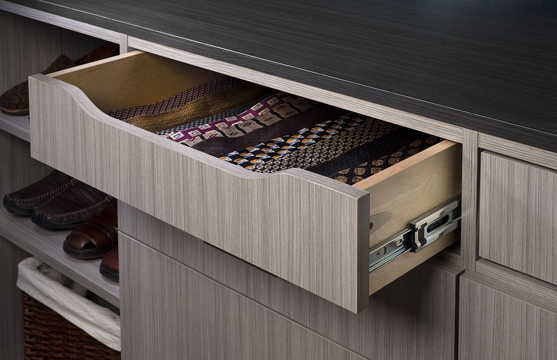 Open closet drawer with ties inside, silver hardware, gray wood grain finish.