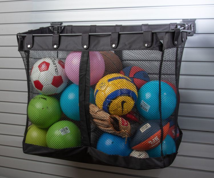 Mesh storage bag filled with sports balls mounted on a wall.