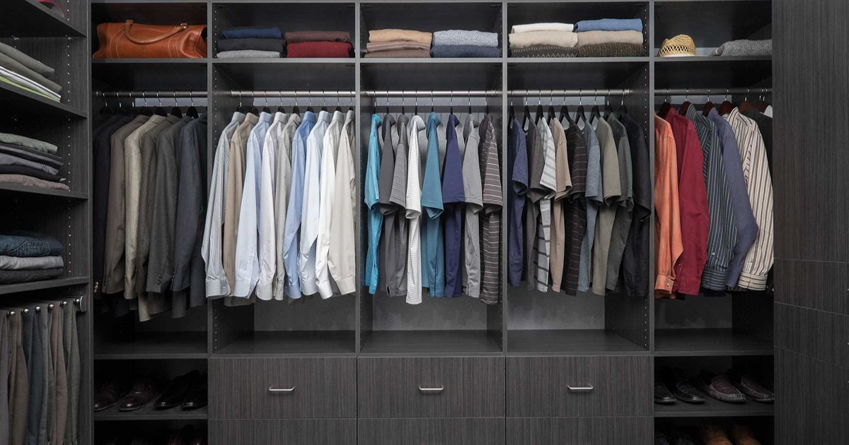 Dark gray closet with hanging shirts, folded clothes, and drawers.