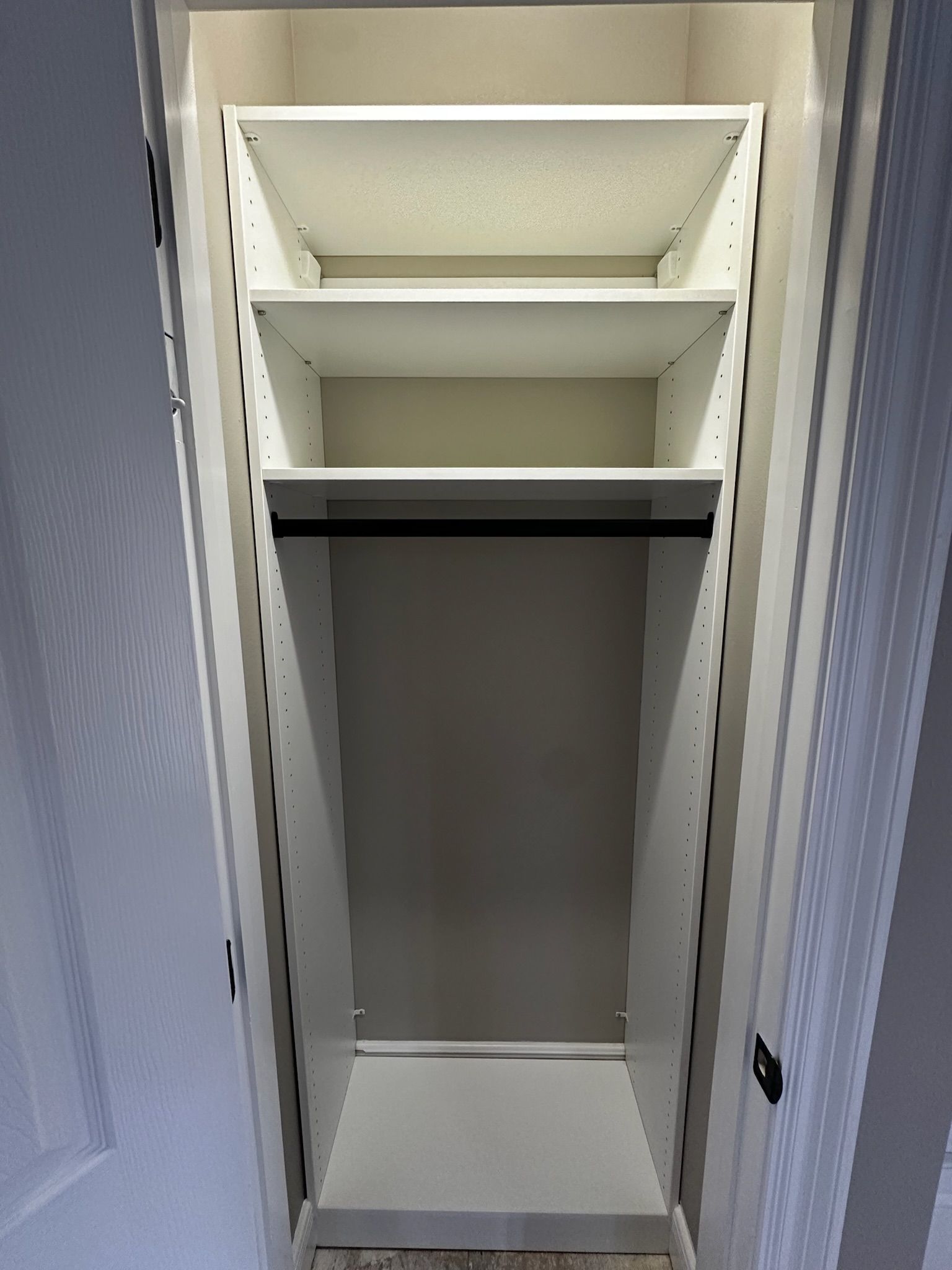 White closet with shelves and a hanging rod, empty and ready for storage.