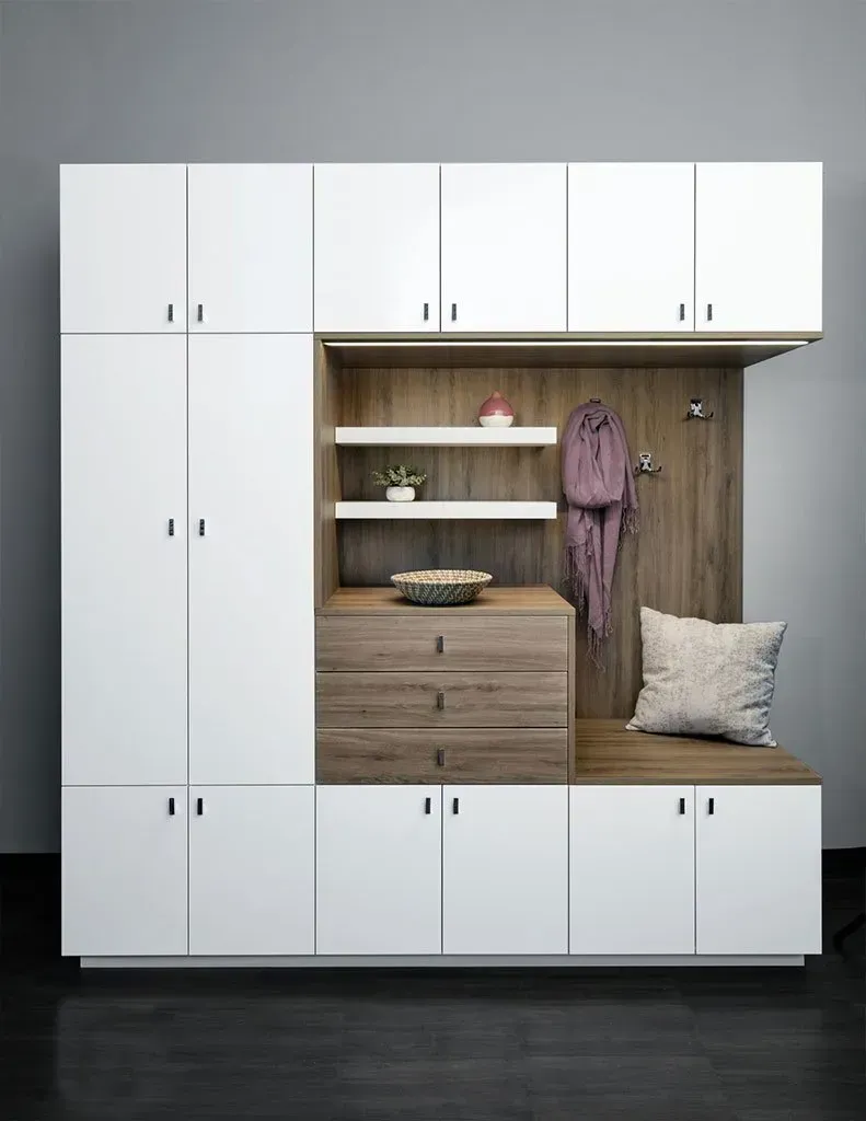 Walk-in closet with white shelving, clothes hanging, drawers, and shoes.