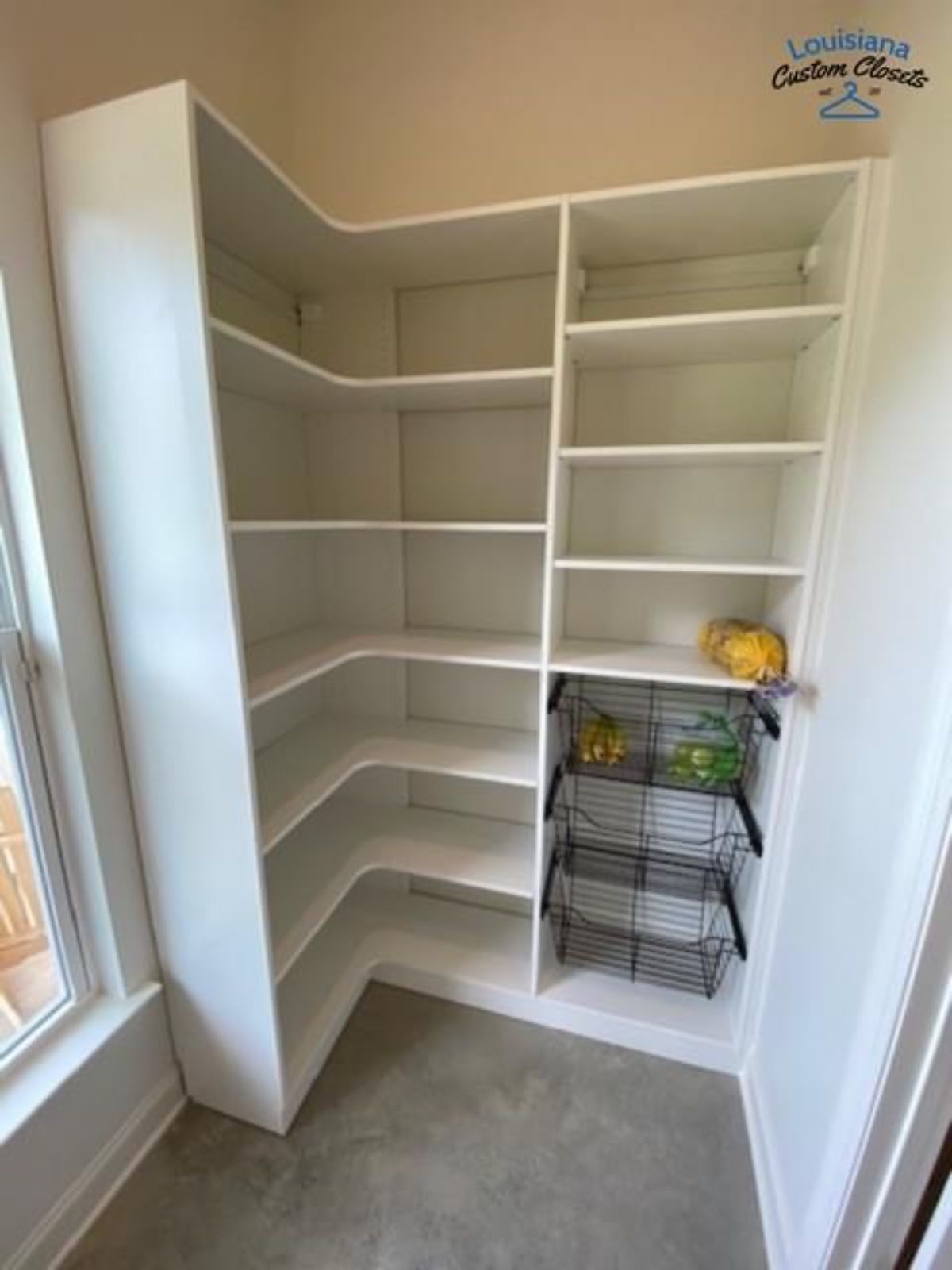 White corner pantry with shelves and wire baskets, located next to a window.