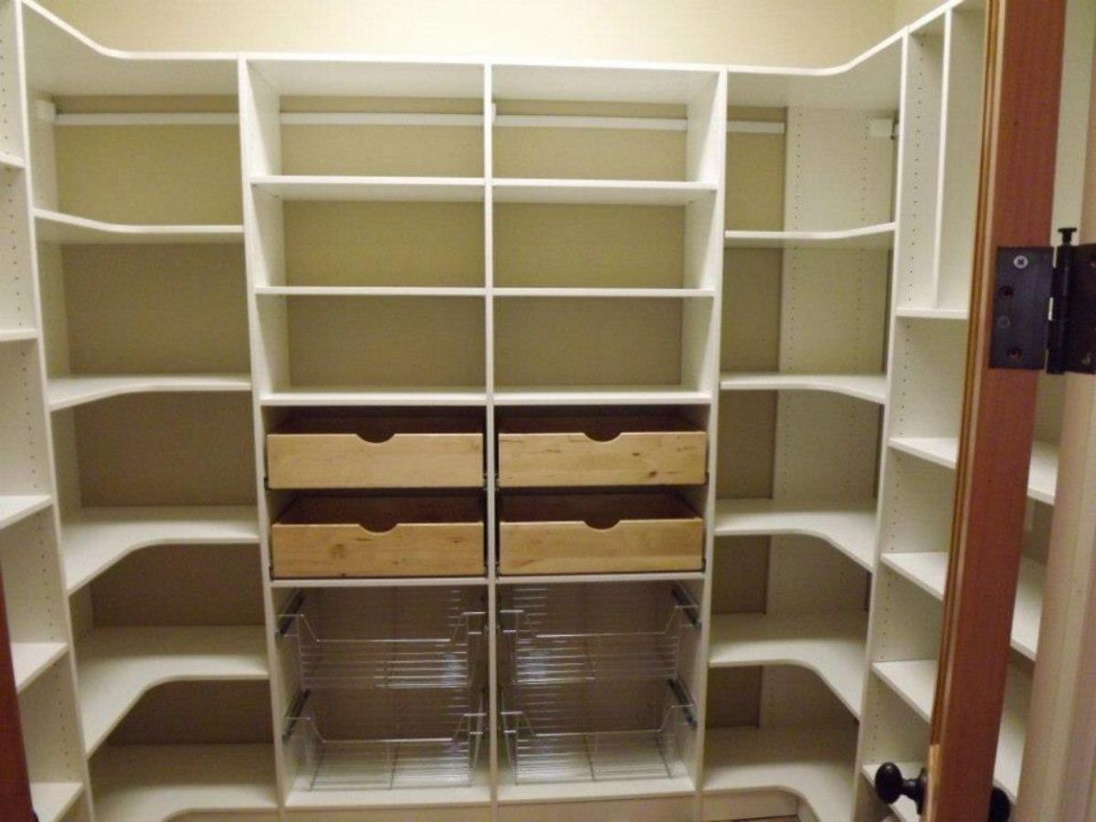 White built-in closet with shelves, drawers, and pull-out organizers. Brown door frame and hinge visible.