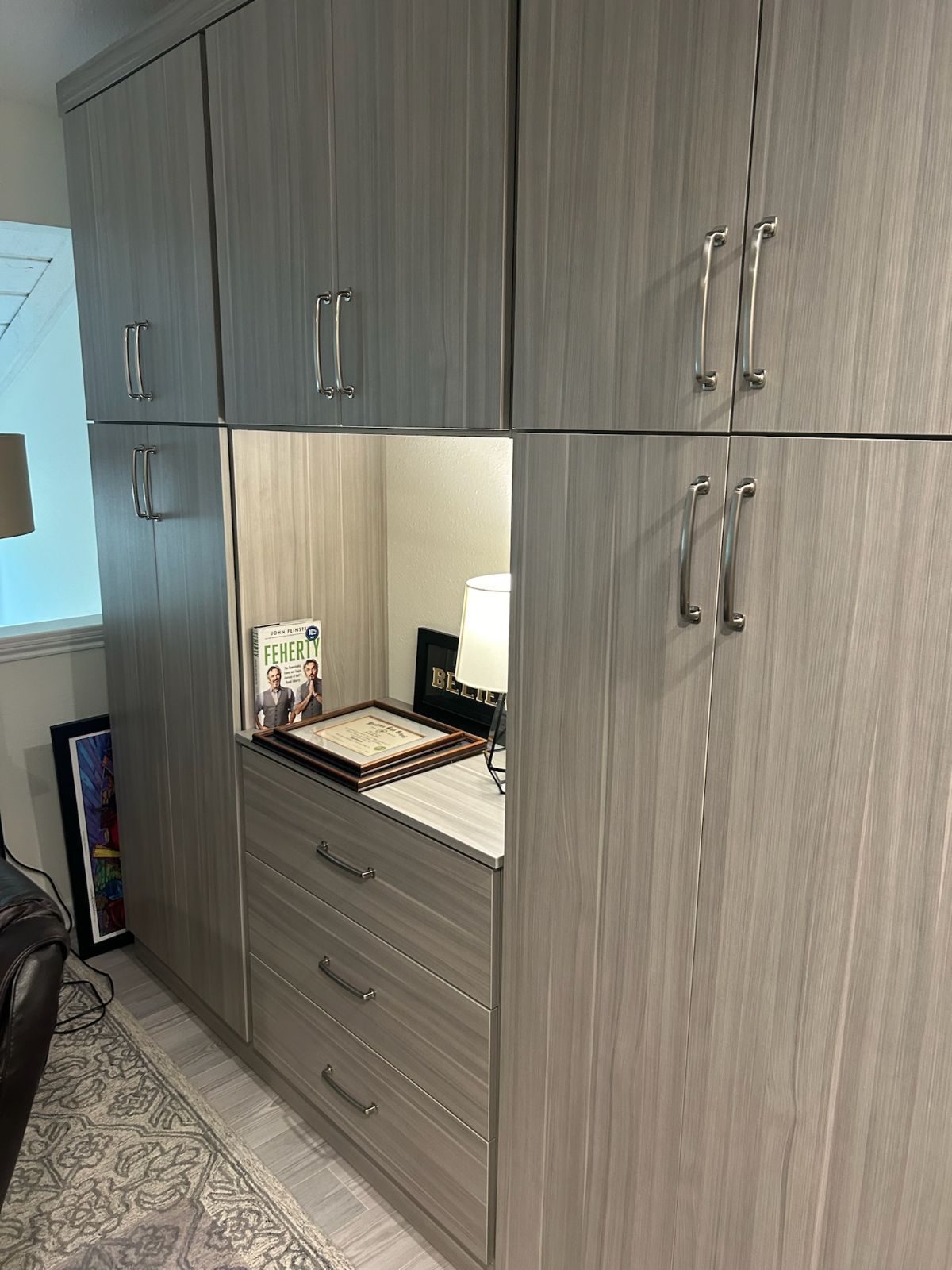 Gray storage cabinets with open cubby and drawers.