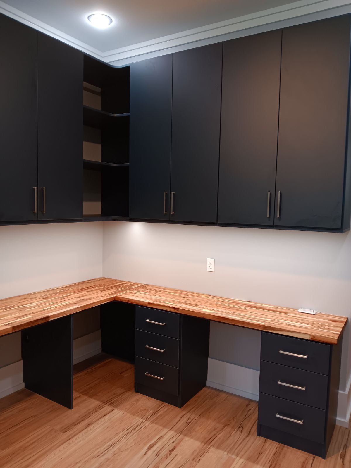 Dark cabinets and wood desk in a corner office space.
