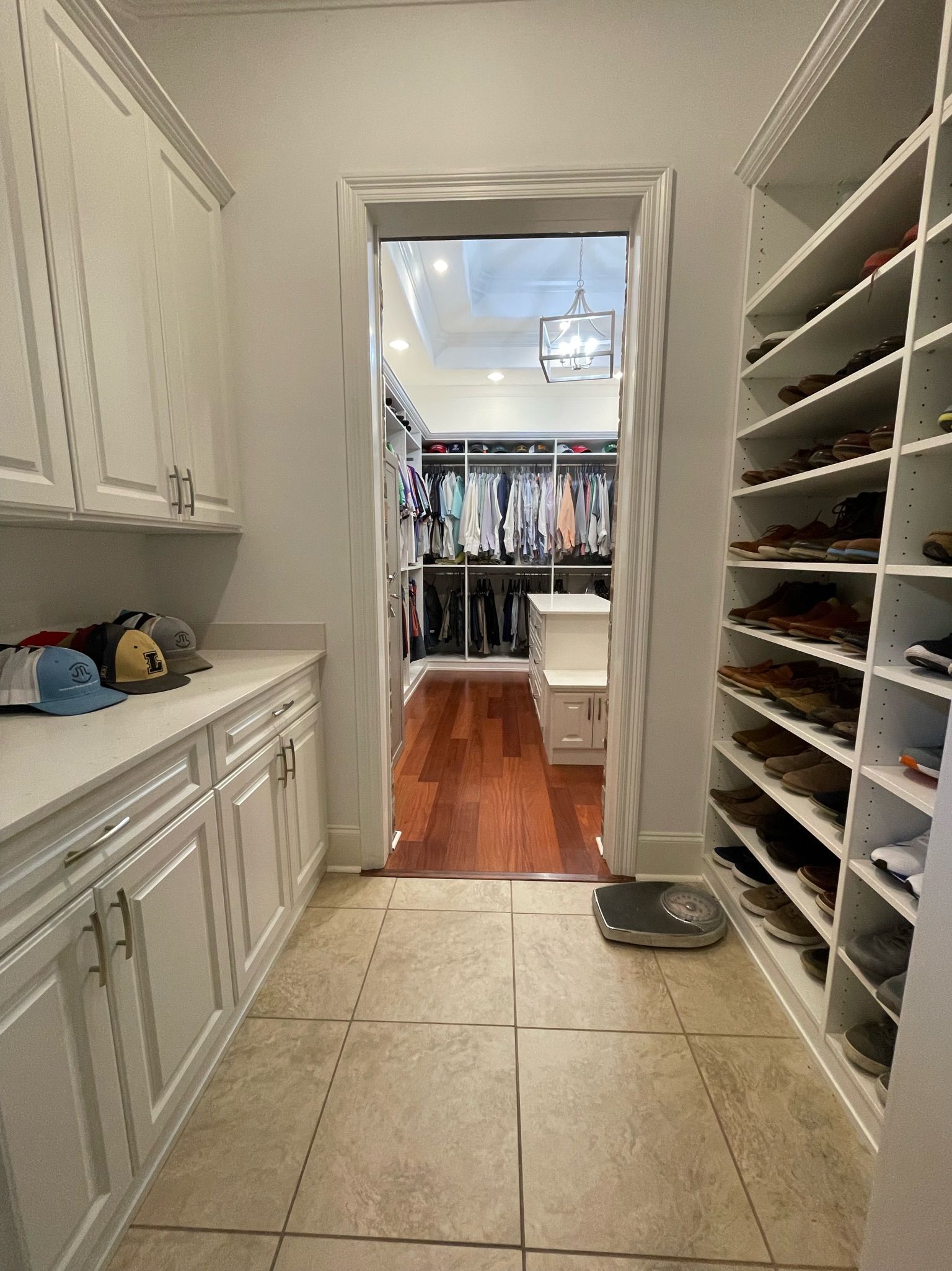 A walk-in closet with shoe shelves and cabinets. The doorway leads to another section of the closet.
