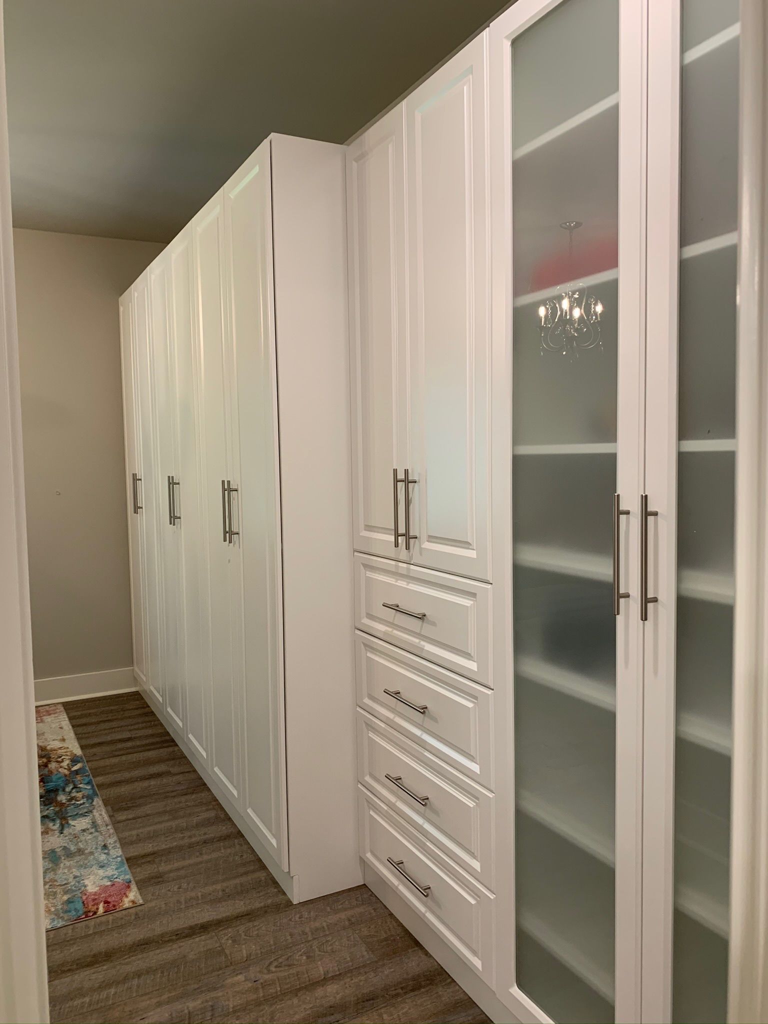 White custom closet with frosted glass doors and drawers.