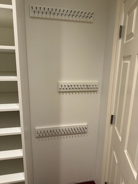 Three white key racks mounted on a white wall; a closet and door are visible.