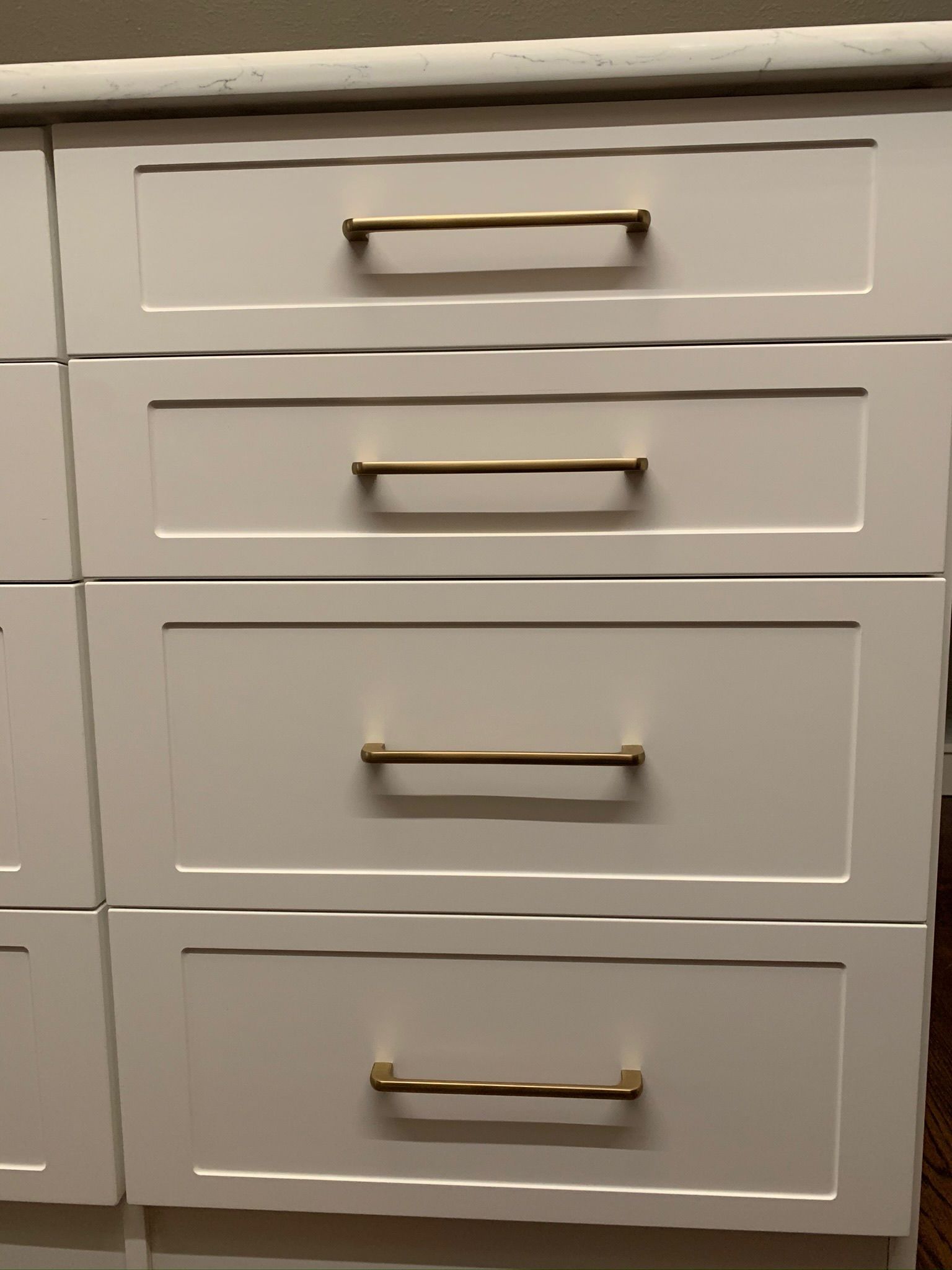 White cabinet drawers with gold handles.