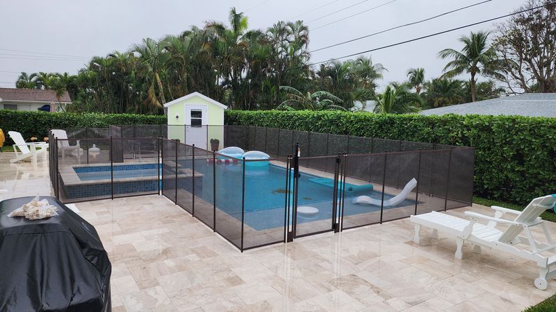 A large swimming pool with a fence around it in a backyard.