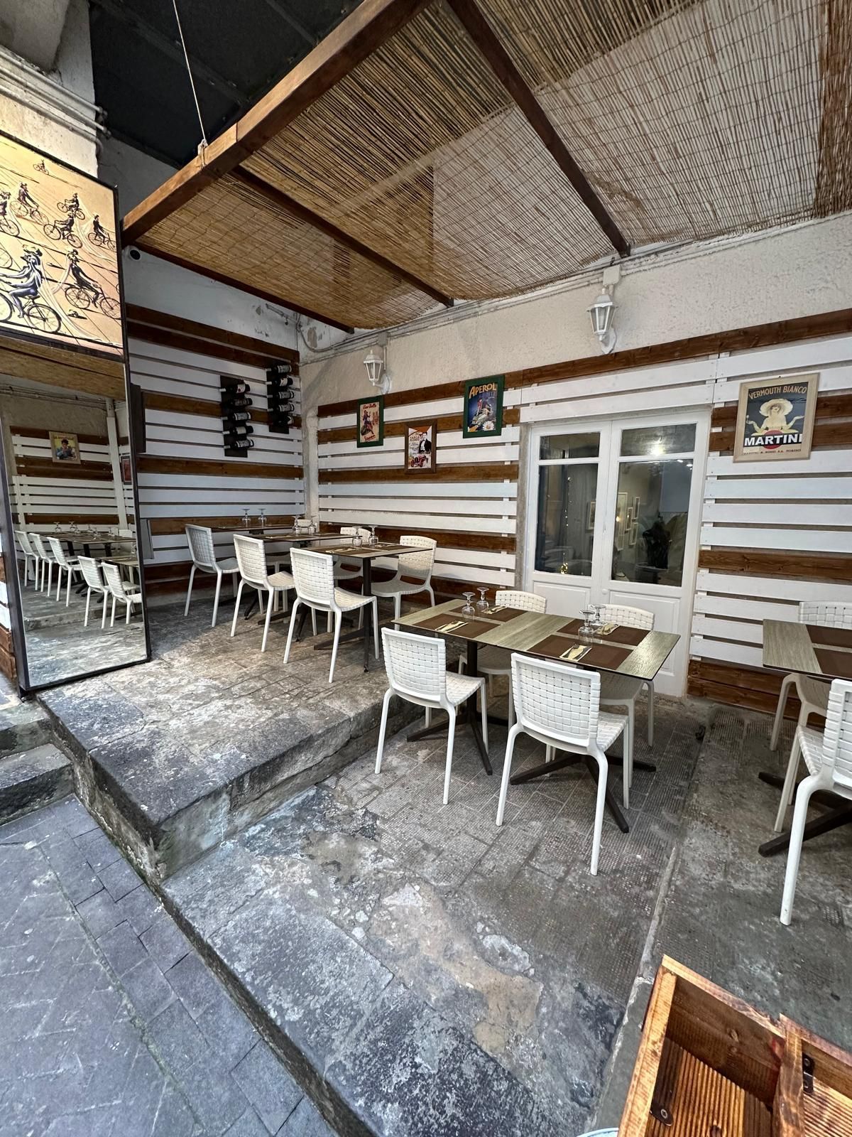 Un ristorante siciliano a Siracusa con tavoli e sedie all'esterno.