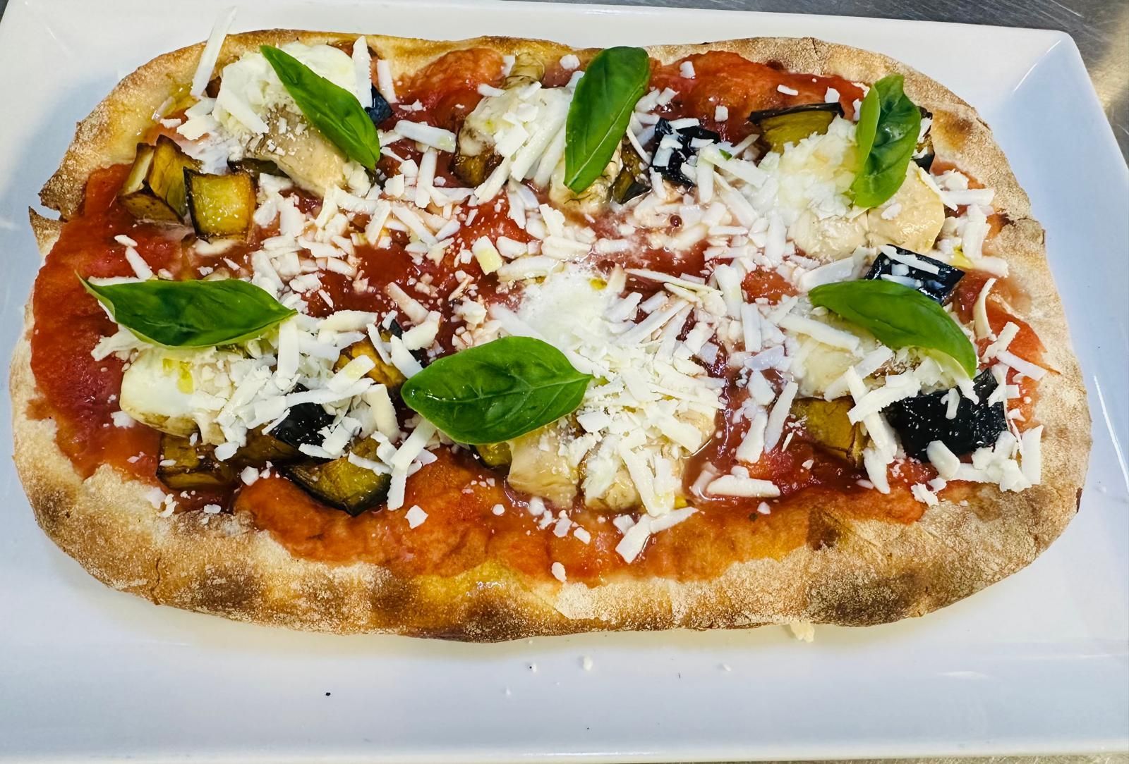 Una pizza con salsa di pomodoro e formaggio su un piatto bianco