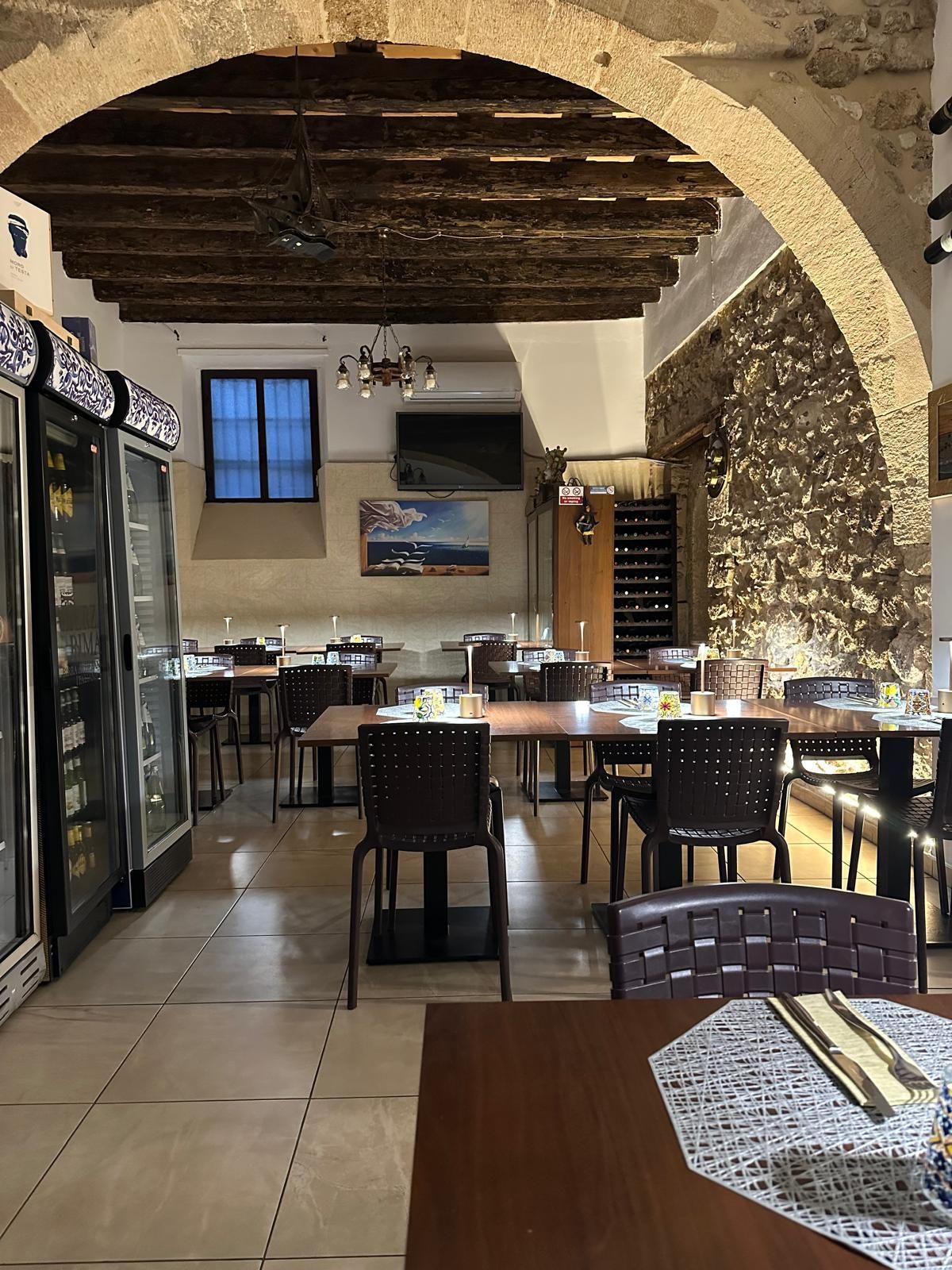 Un ristorante siciliano a Siracusa con molti tavoli e sedie