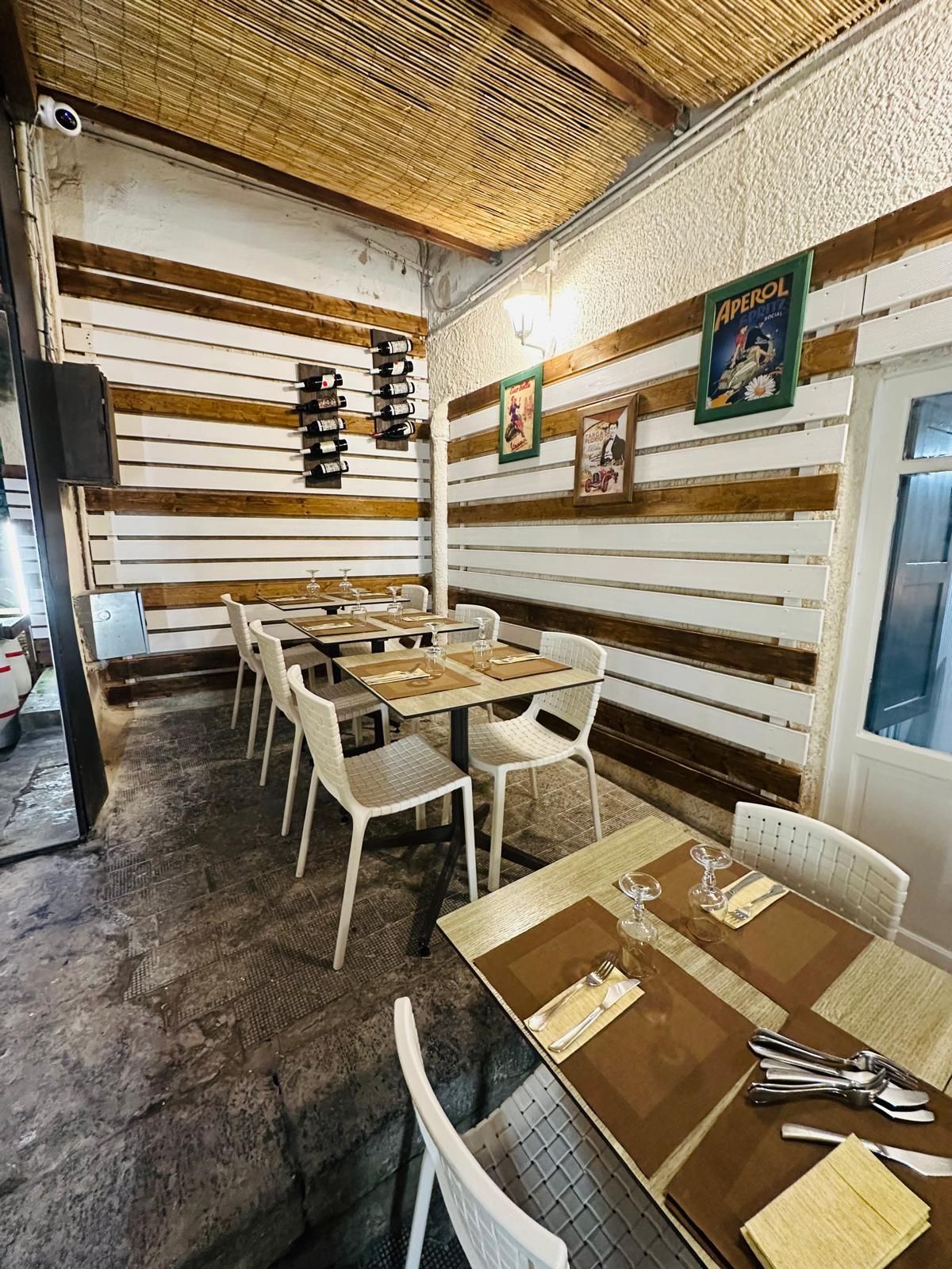 Un ristorante tradizionale a Siracusa con tavoli, sedie e tetto di paglia.