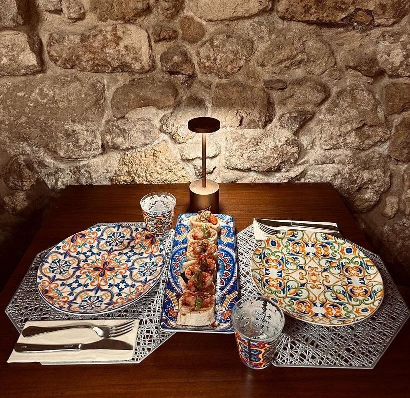 Un paio di vasi con delle teste sopra sono appoggiati su un tavolo.