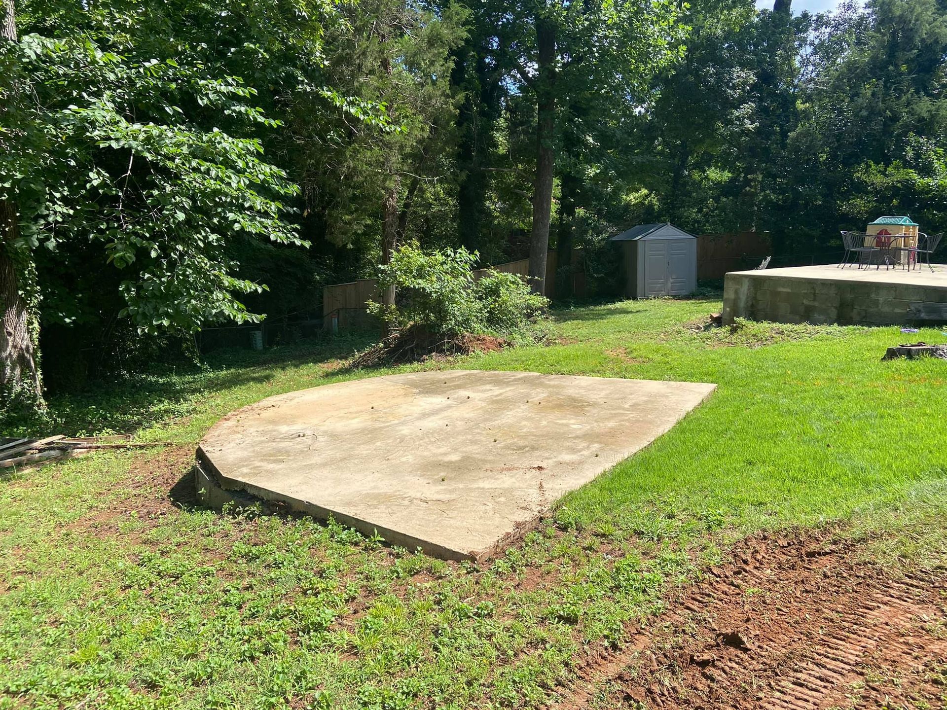 A large concrete slab is sitting in the middle of a lush green field.