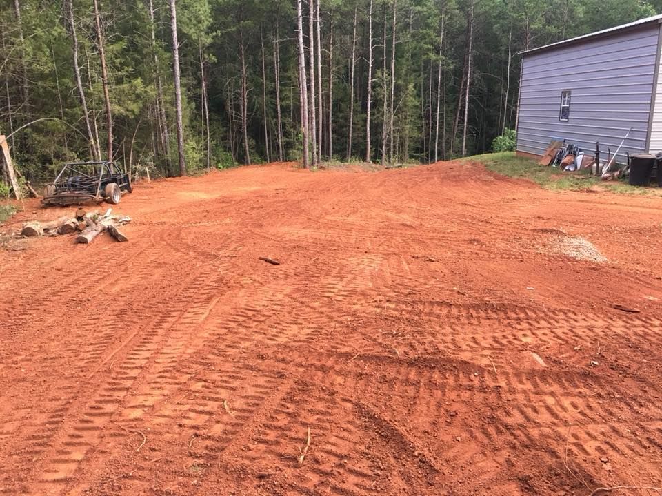 A dirt road leading to a house in the woods.