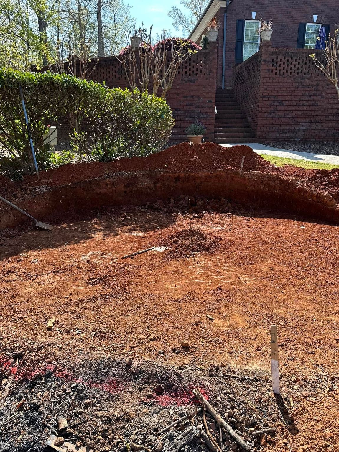 A pile of dirt is sitting in front of a brick house.