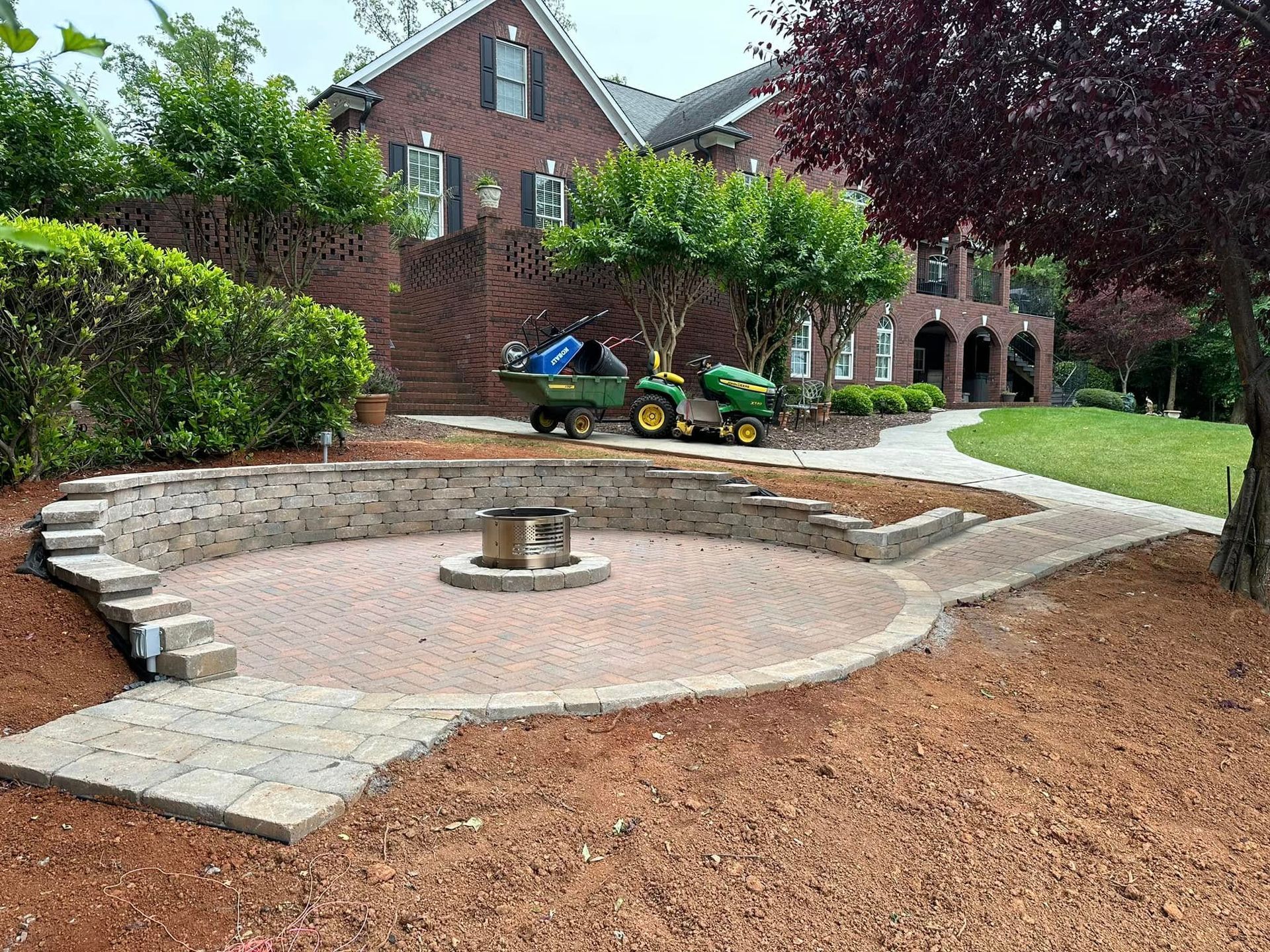 A fire pit is being built in front of a large brick house.