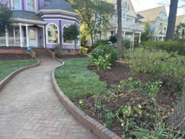 A brick walkway leading to a purple house
