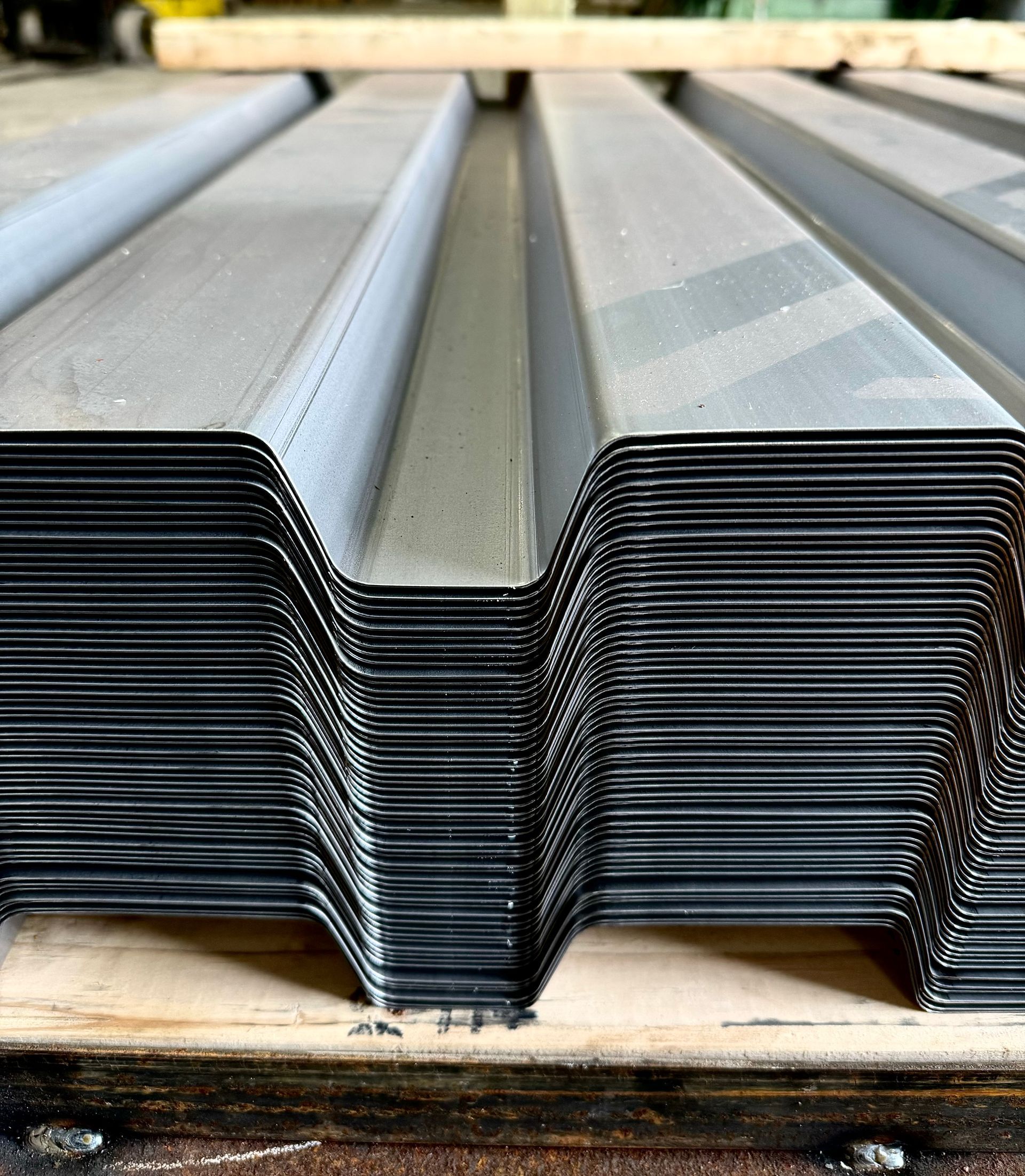 A stack of metal sheets sitting on top of a wooden pallet.