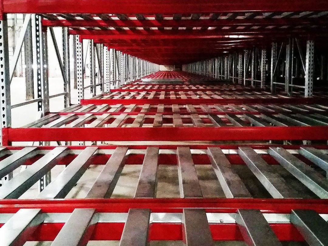 A warehouse with a lot of shelves and a lot of red shelves