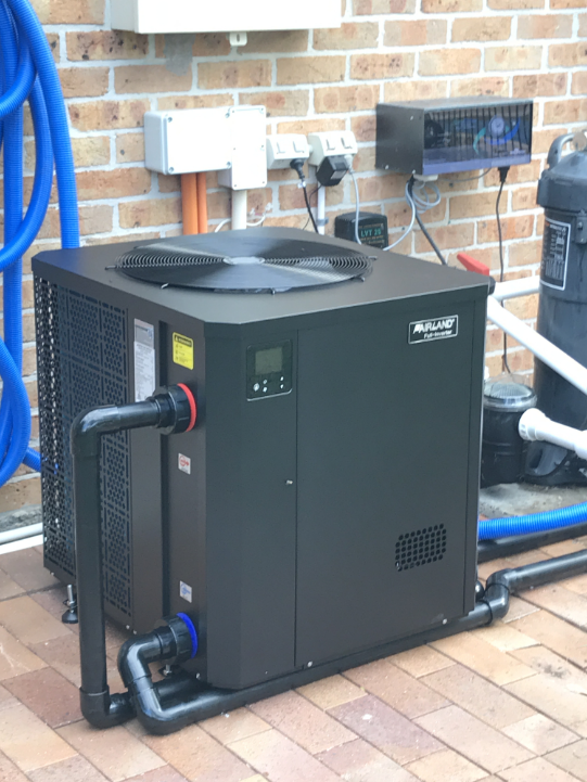 A Large Black Box is Sitting Next to a Brick Wall — Newcastle Solar Pool Heating Systems In Port Stephens, NSW