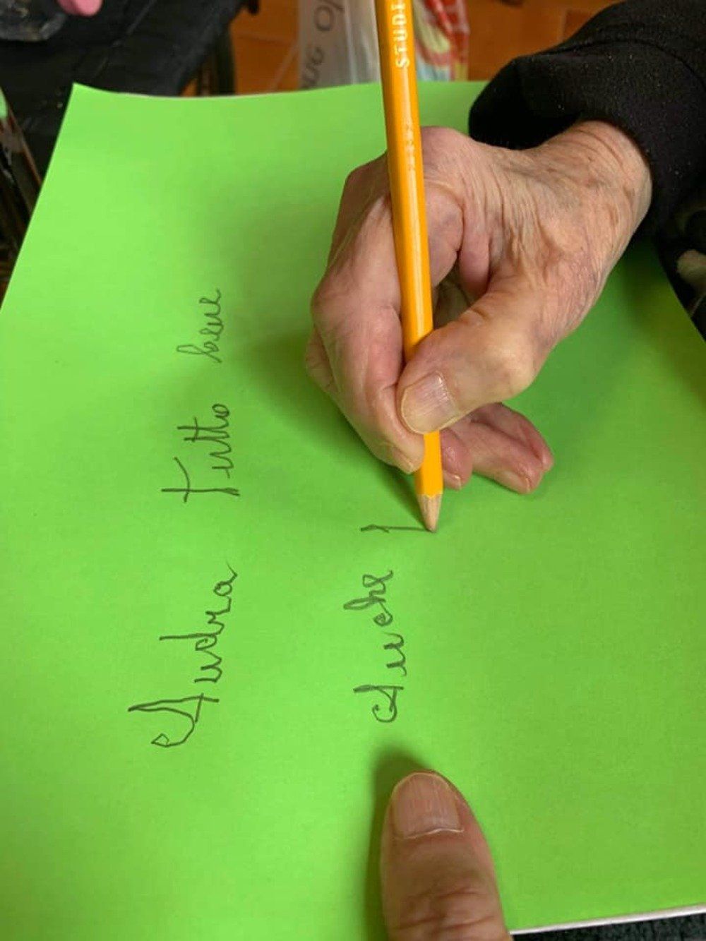 anziana che scrive su un cartellone