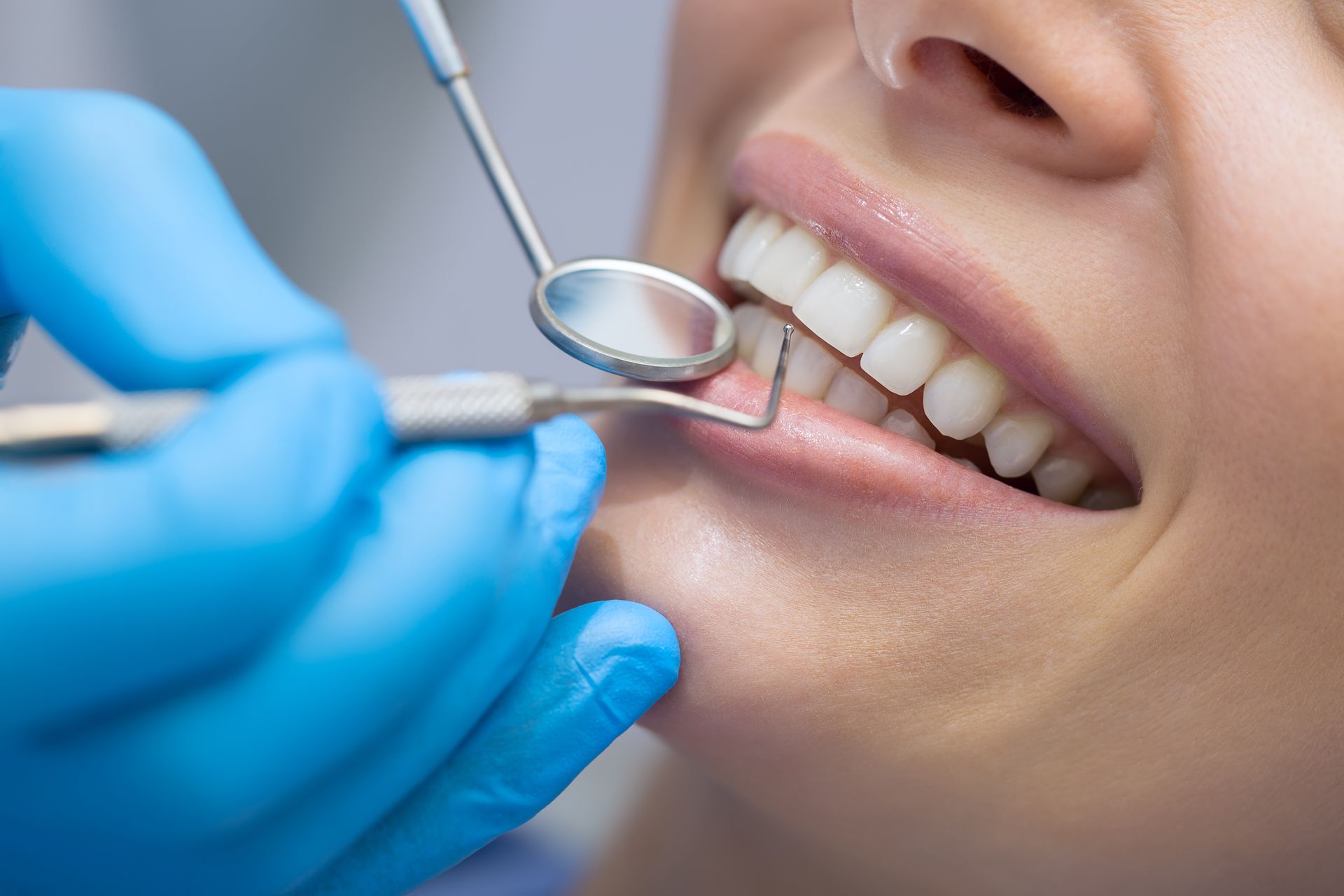 Close-up of a patient getting her teeth examined by a dentist.
