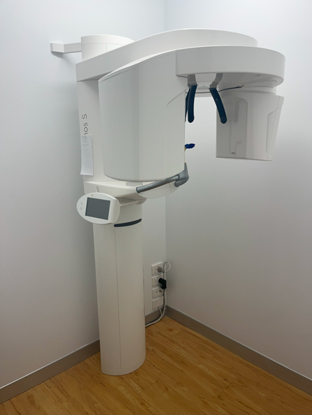 An x-ray machine is sitting in a corner of a room.