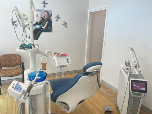 A dental office with a chair and a machine