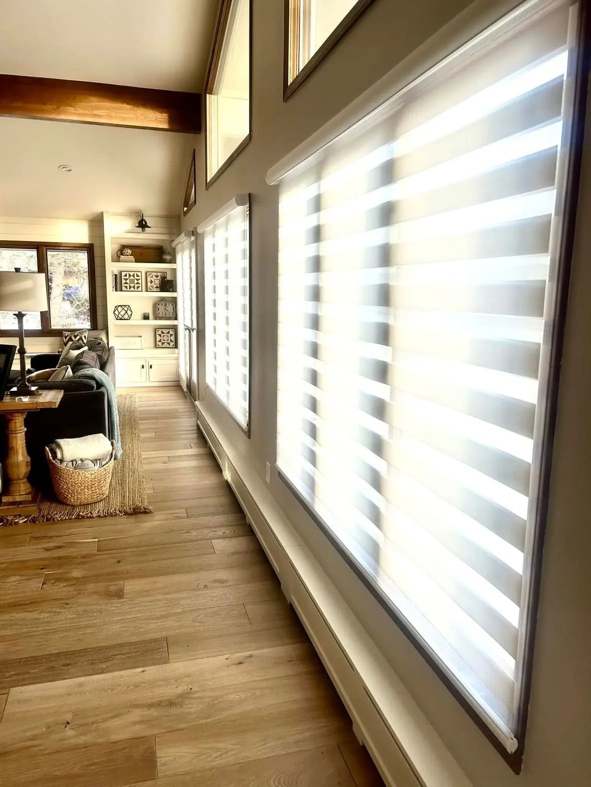 A living room with a lot of windows and blinds on the windows.