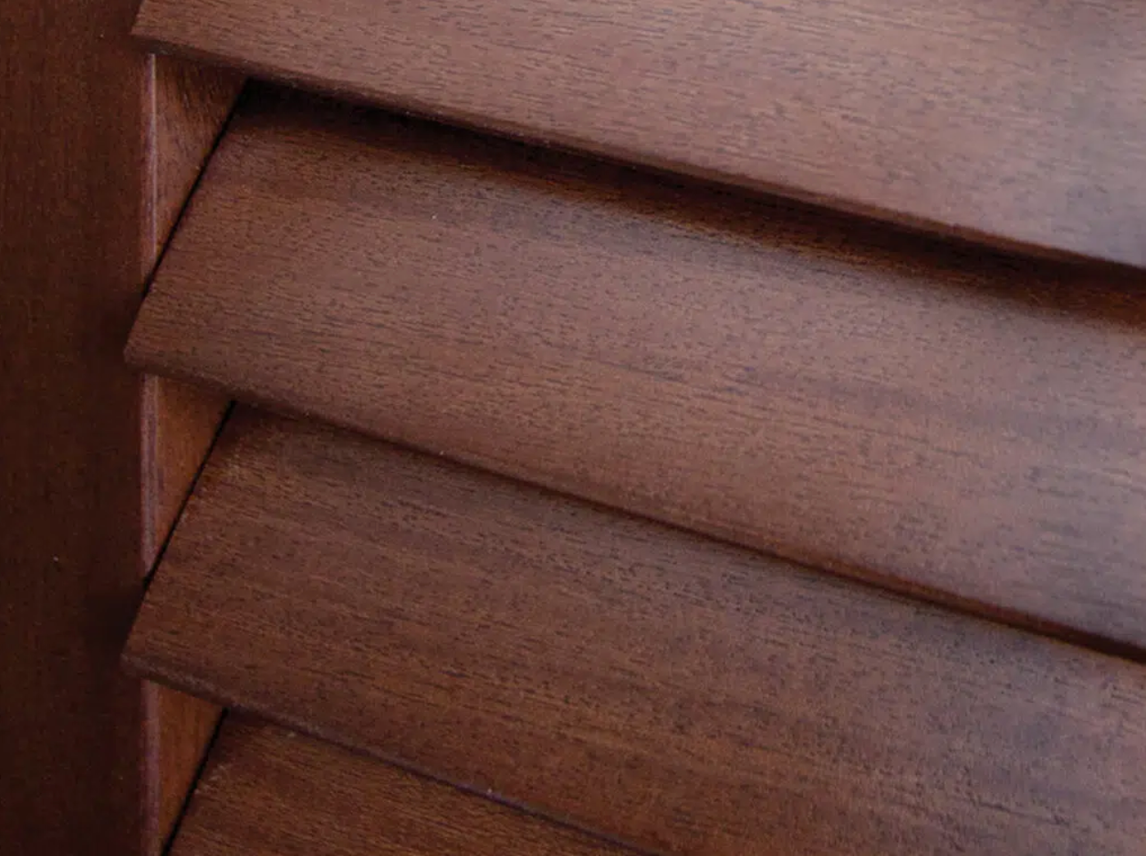 A close up of a wooden blind on a window.
