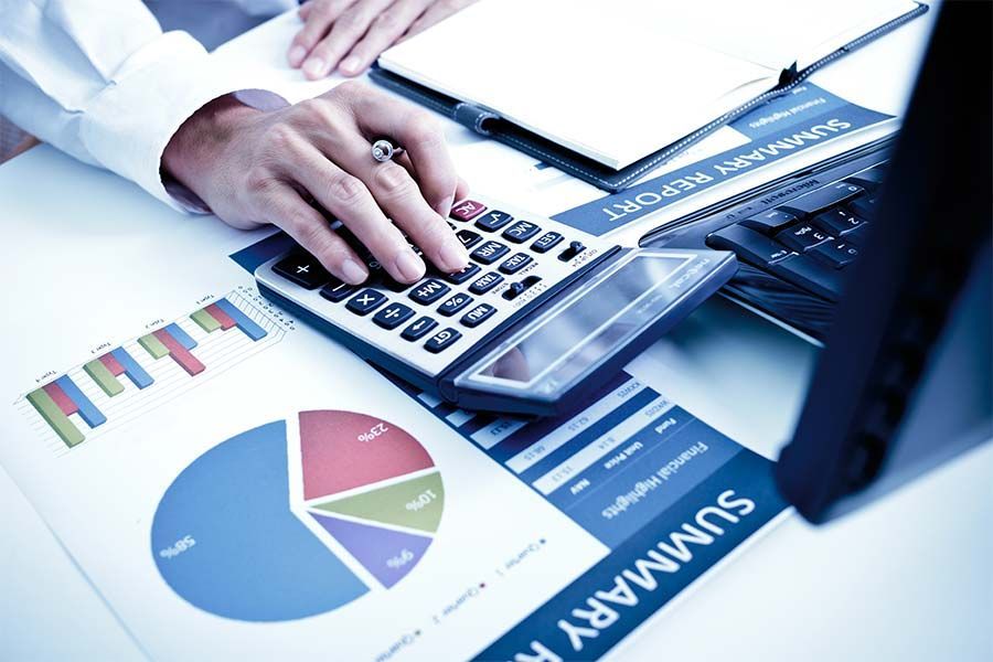 A Person is Using a Calculator and a Laptop on a Table — Peter Maundrell & Company Pty Ltd in Emerald, QLD