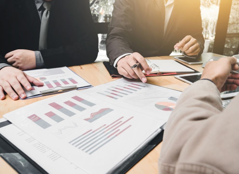A Group of People Are Sitting at a Table Looking at Graphs — Peter Maundrell & Company Pty Ltd in Emerald, QLD