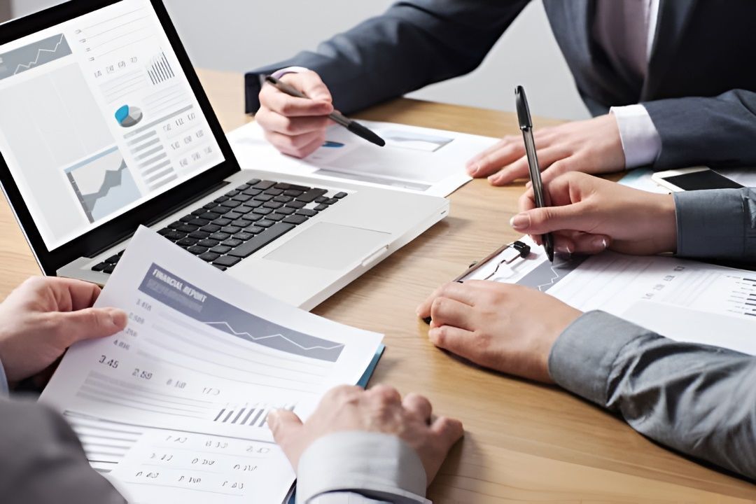 Group of People Are Sitting at a Table Looking at Papers and a Laptop — Peter Maundrell & Company Pty Ltd in Springsure, QLD