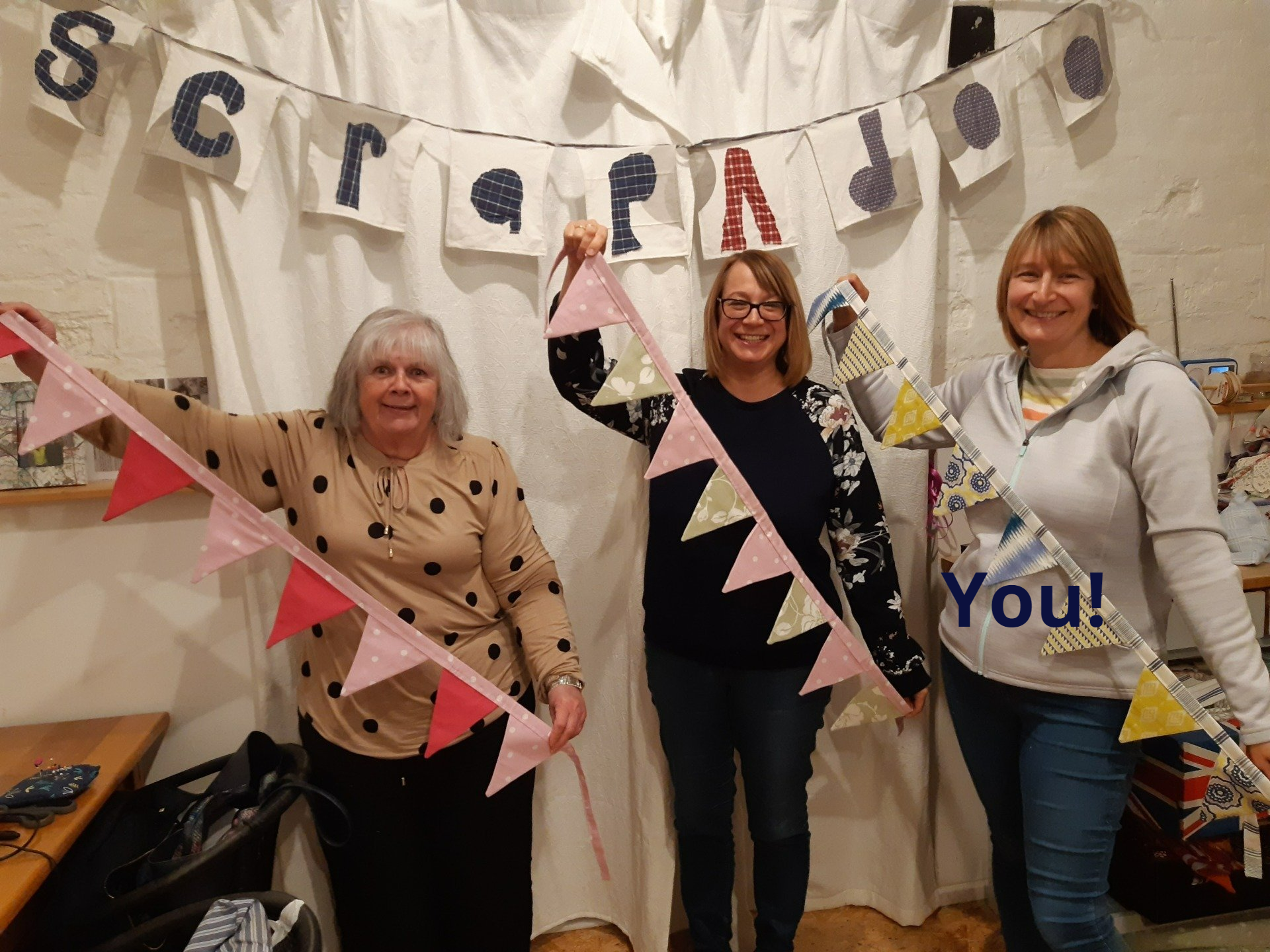 three ladies holding bunting