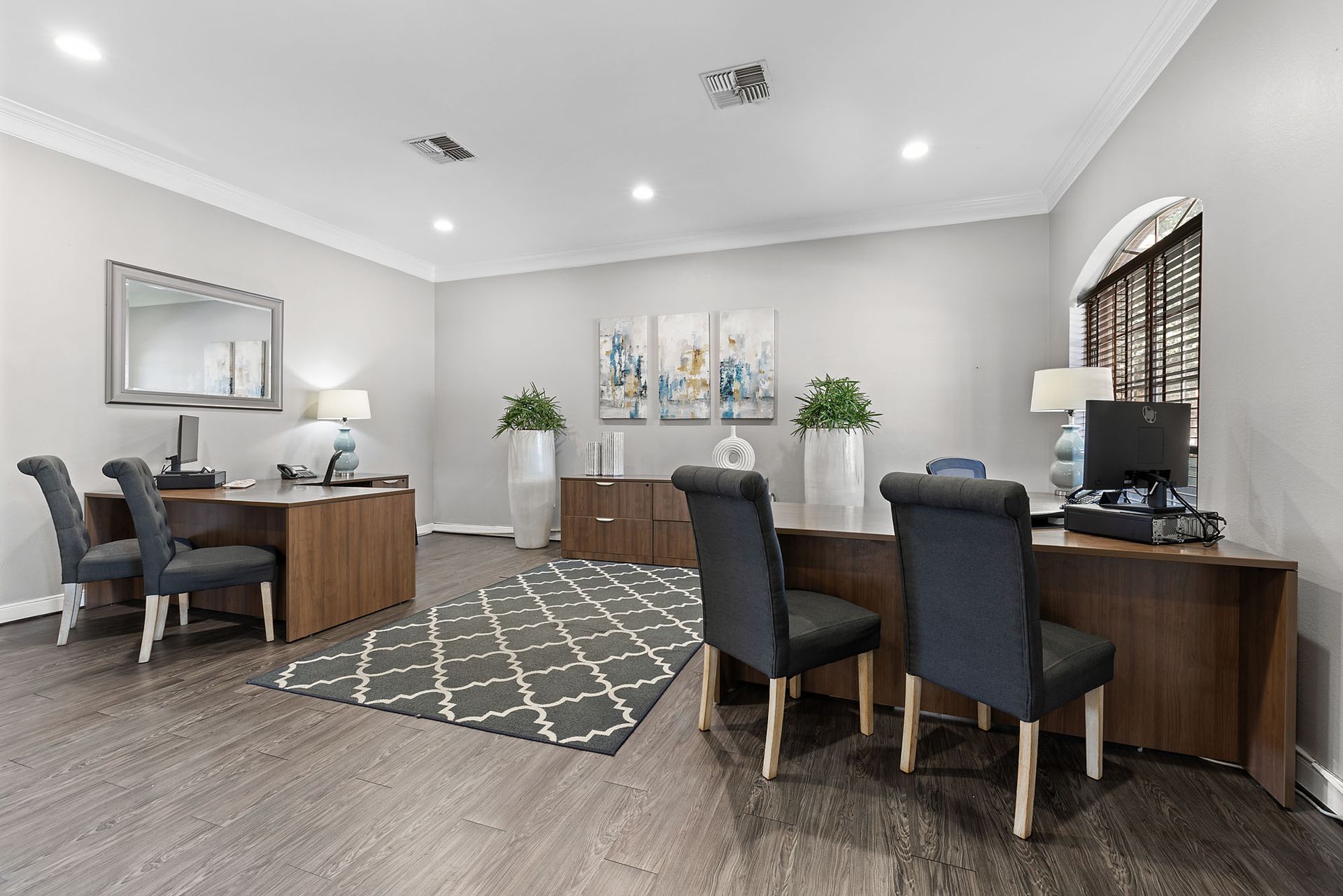 Leasing office reception area with two desks, chairs, and modern decor.